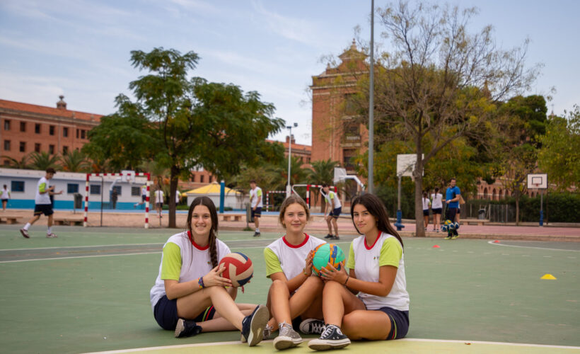 Alumnas posando con un balón de voleyball antes de practicar deporte en el colegio